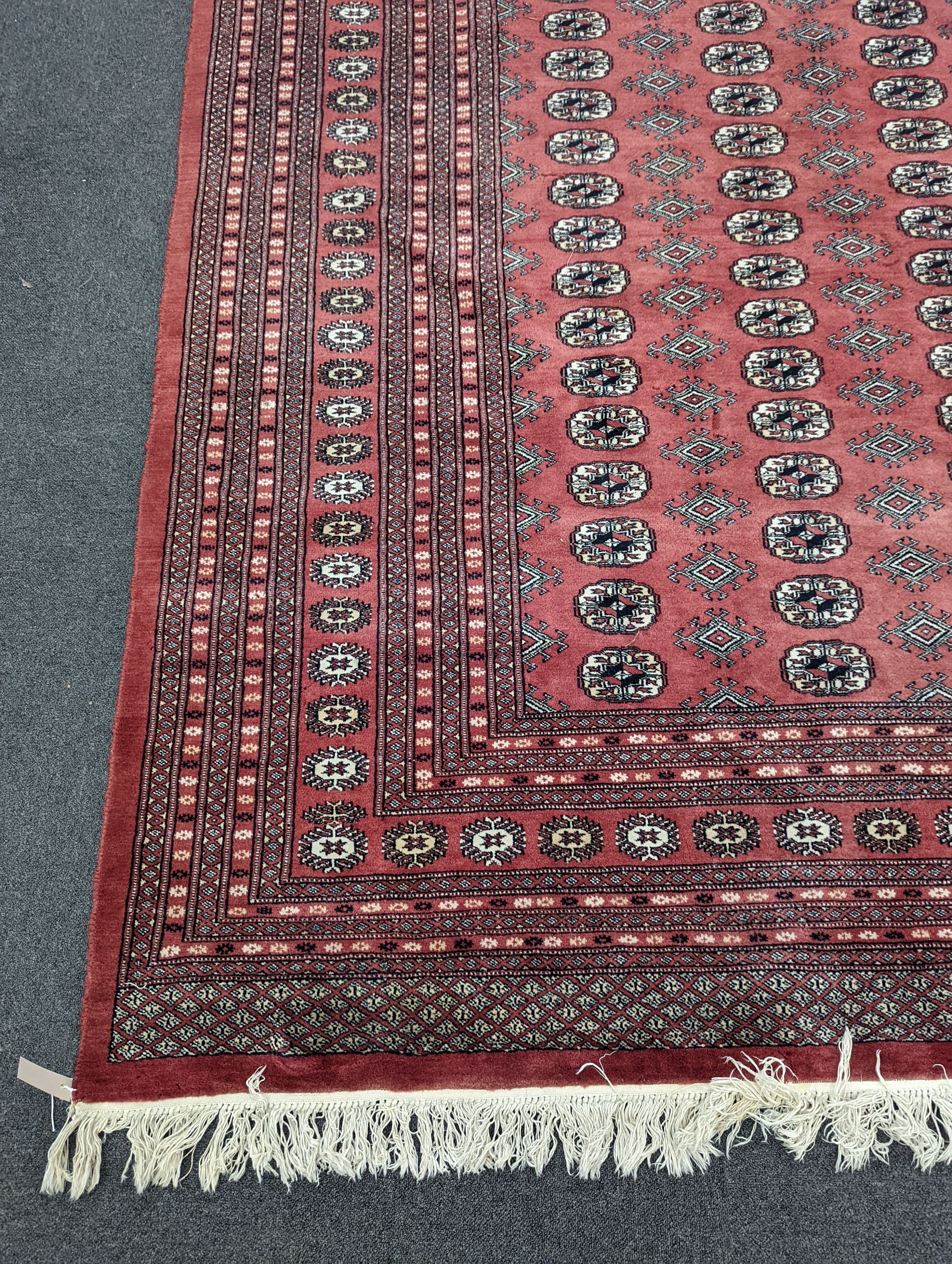 A Bokhara burgundy ground carpet, 360 x 276cm